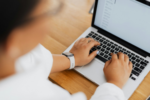 Person shown using a laptop and typing an email